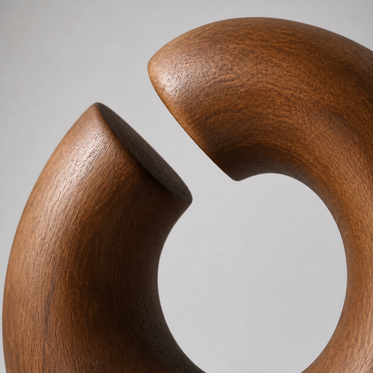 Severed Loop, teak wood tabletop sculpture — wood grain and carved detail